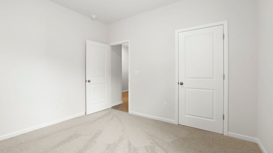 Bedroom with carpet and windows.