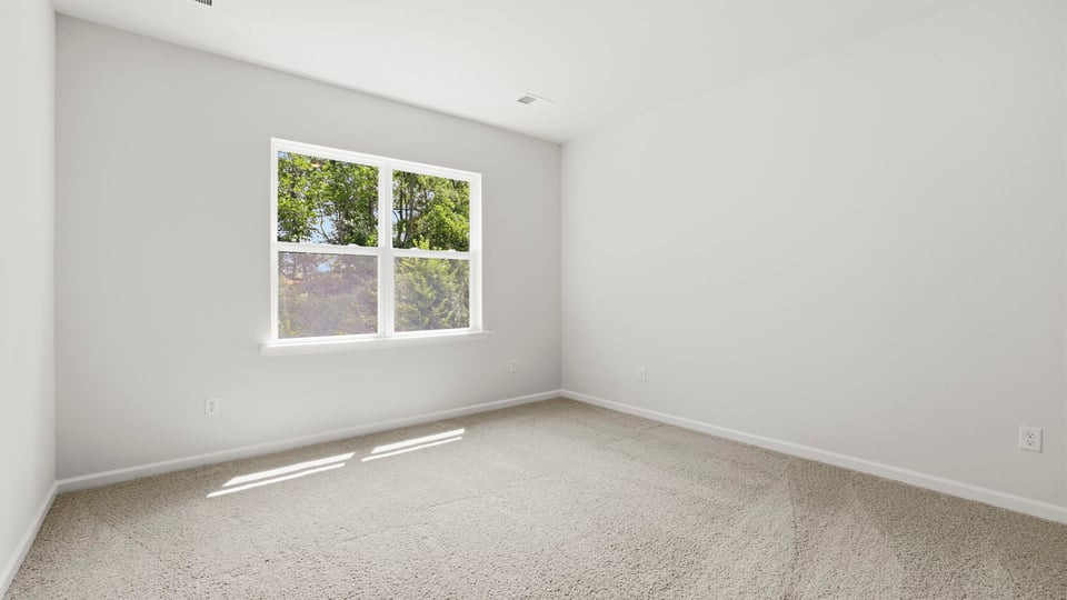 Bedroom with carpet and windows.