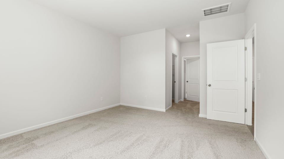 Bedroom with carpet and windows.