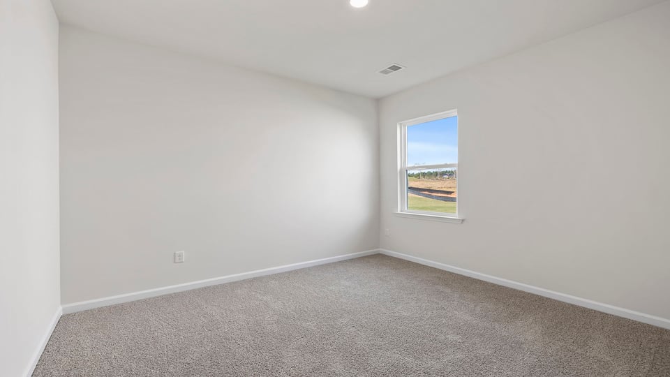 Bedroom with carpet and windows.