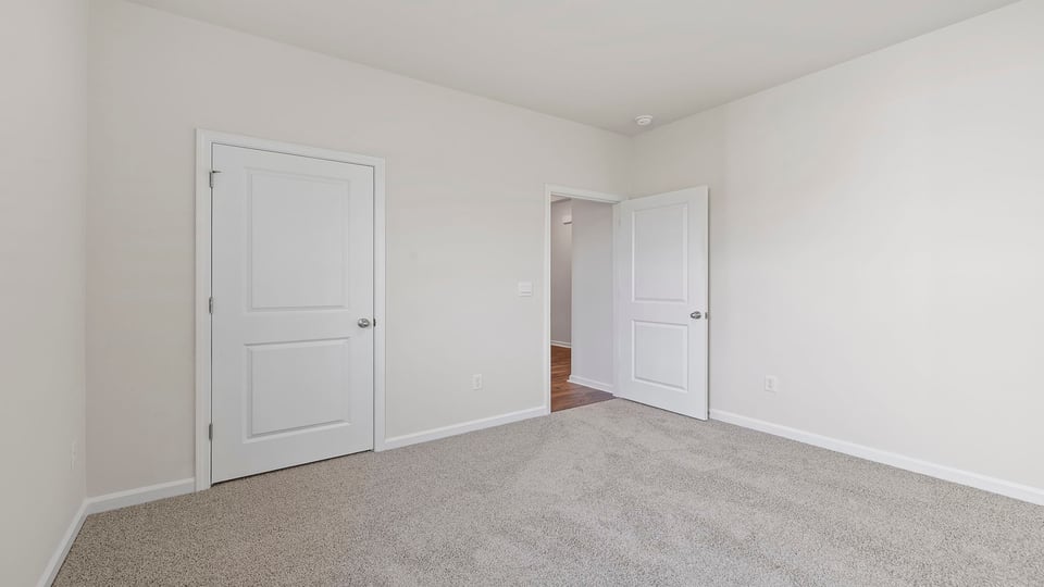 Bedroom with carpet and windows.