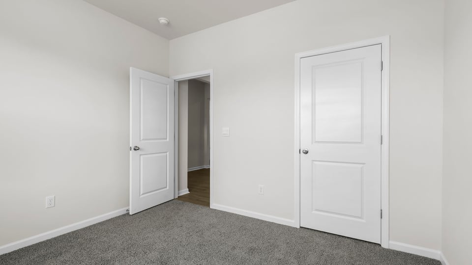 Bedroom with carpet and windows.