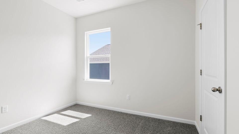 Bedroom with carpet and windows.