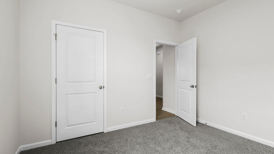 Bedroom with carpet and windows.