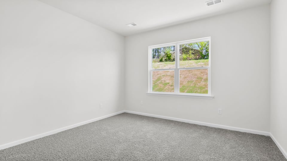 Bedroom with carpet and windows.