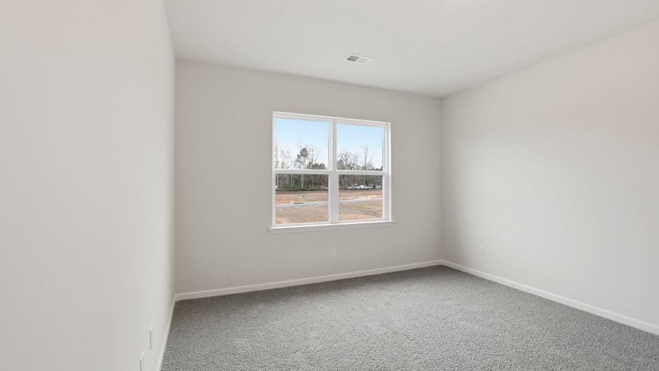Primary bedroom with double window and carpet.