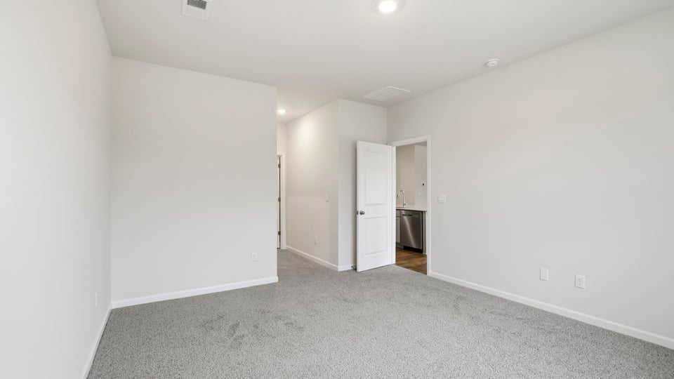 Primary bedroom with carpet.