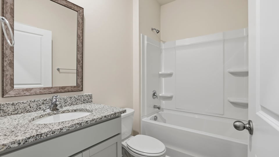 Hall bathroom with vanity and combination shower / tub.