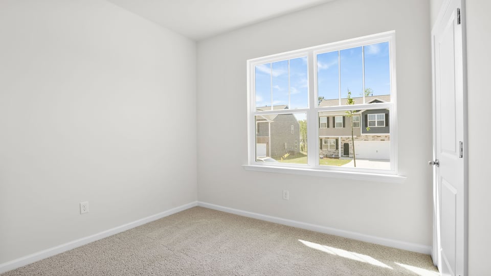 Bedroom with carpet and windows.