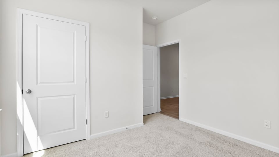 Bedroom with carpet and windows.