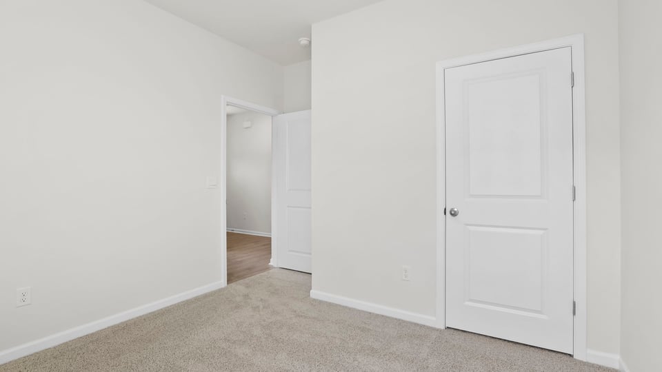 Bedroom with carpet and windows.