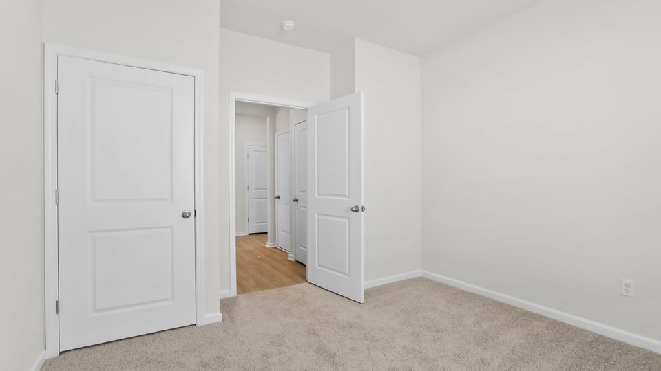 Bedroom with carpet and windows.