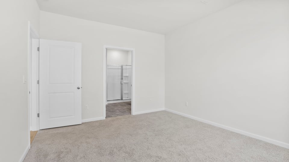 Primary bedroom with carpet and windows/