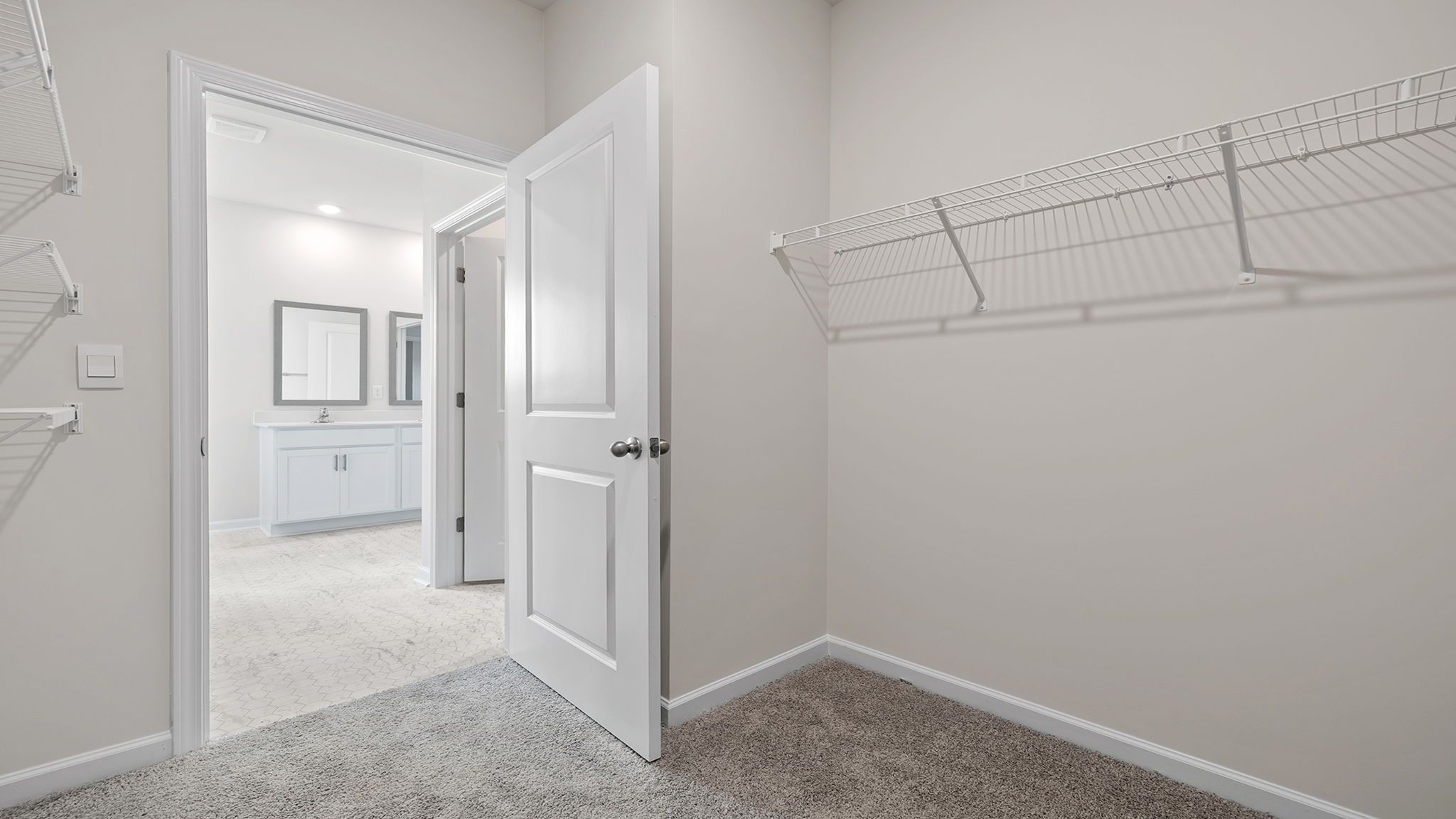 Primary closet with carpet and shelf.