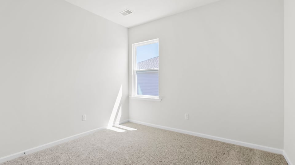 Bedroom with carpet and window.