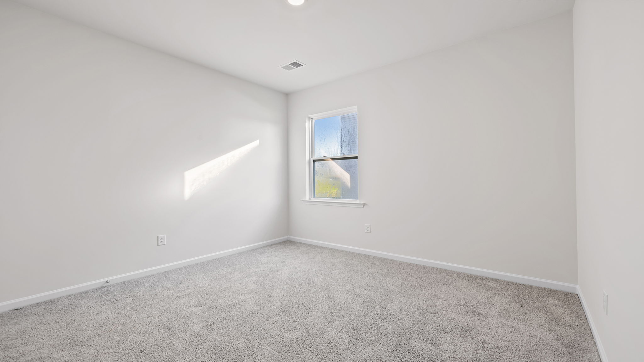 Front bedroom with window and carpet.
