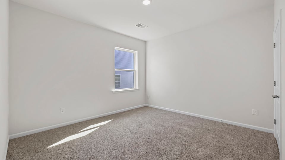 Bedroom with window and carpet.