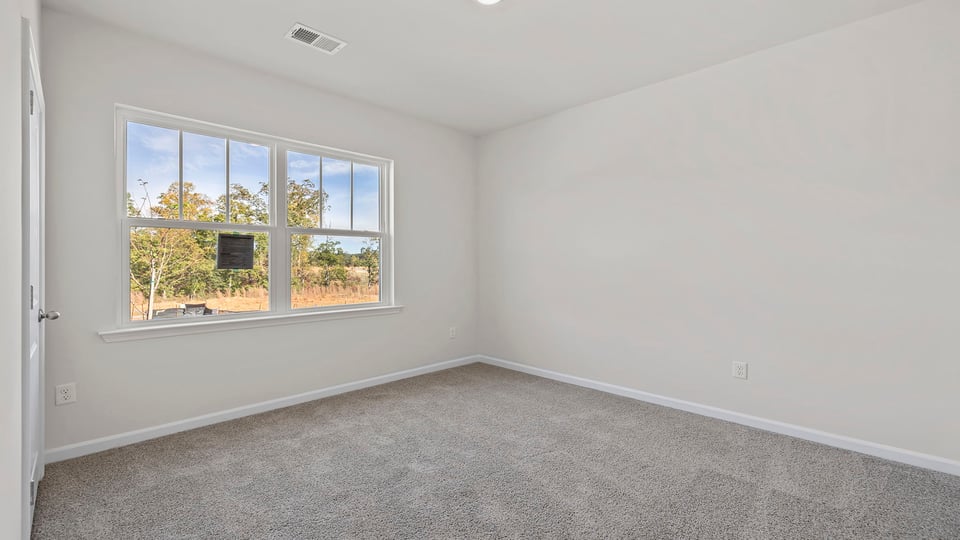 Bedroom with window and carpet.