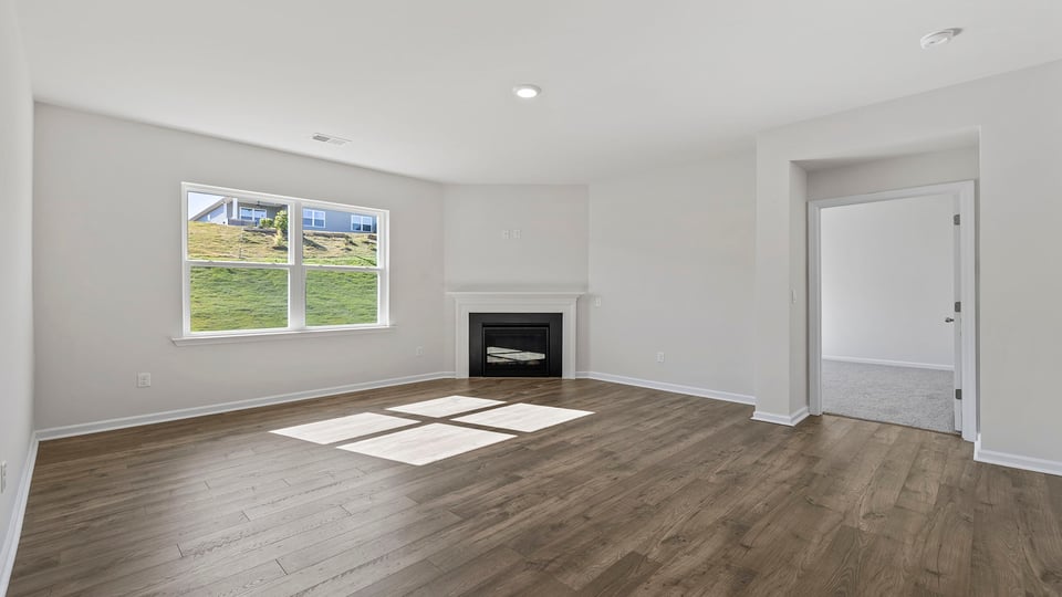 View of family room with gas log fireplace and window.