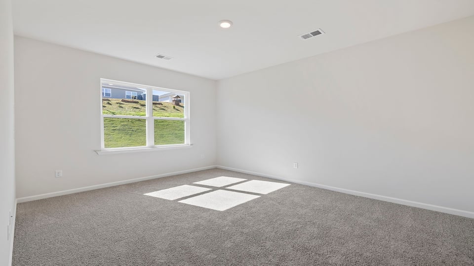 Primary bedroom with window and carpet.