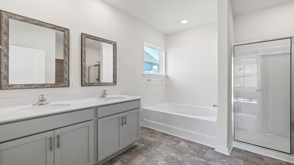 Primary bathroom with dual sink vanity and mirrors.
