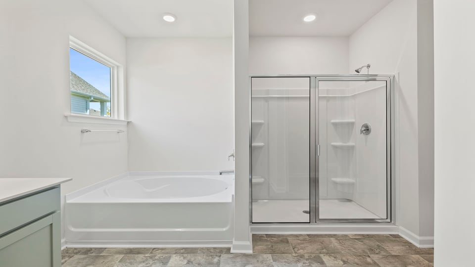 Primary bathroom with walk-in shower and garden tub.