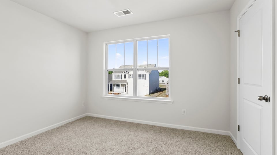 Bedroom with carpet and windows.