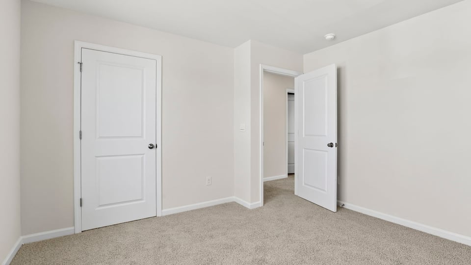 Bedroom with carpet and windows.