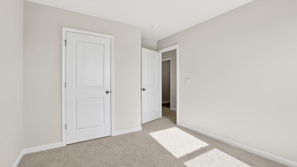Bedroom with carpet and windows.