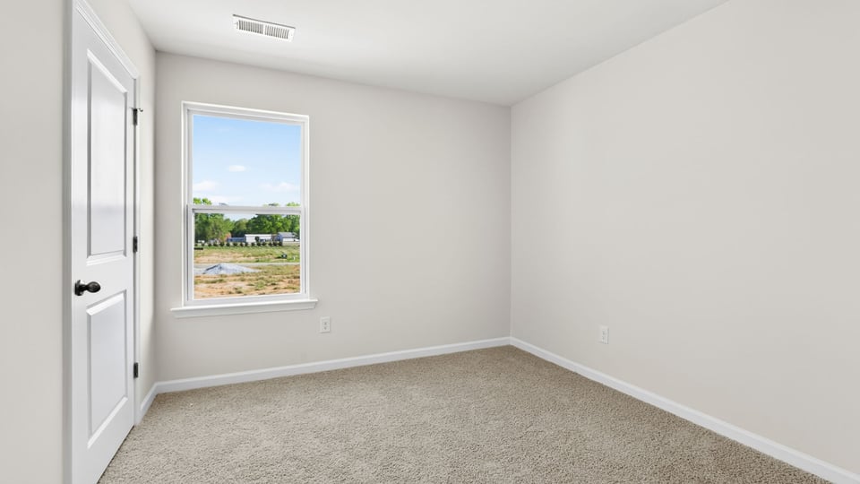 Bedroom with carpet and windows.