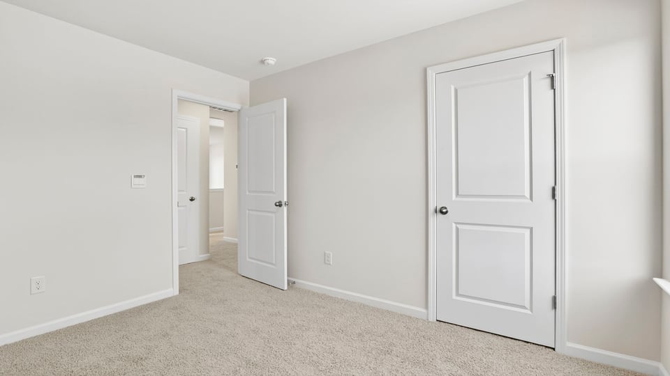 Bedroom with carpet and windows.