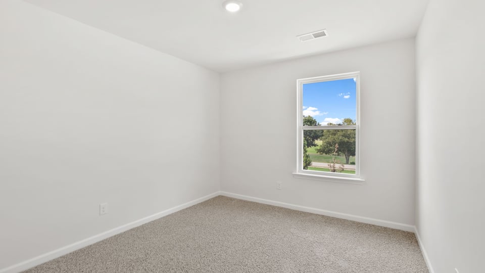 Bedroom with carpet and windows.