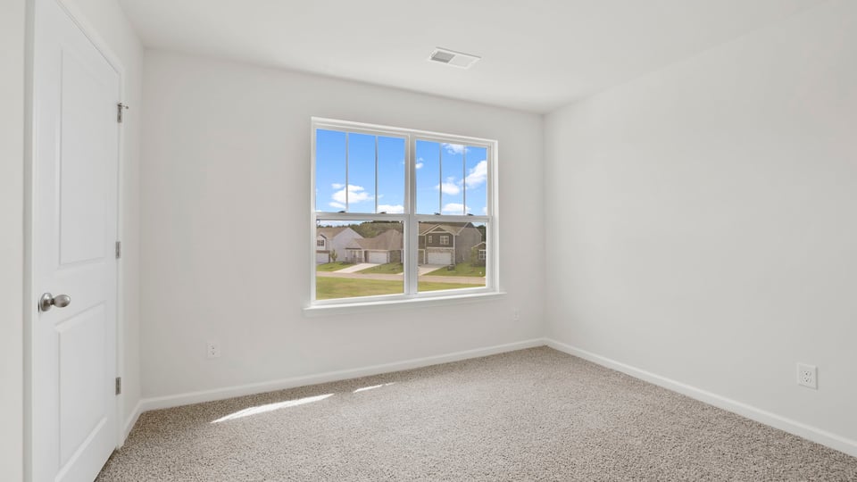Bedroom with carpet and windows.