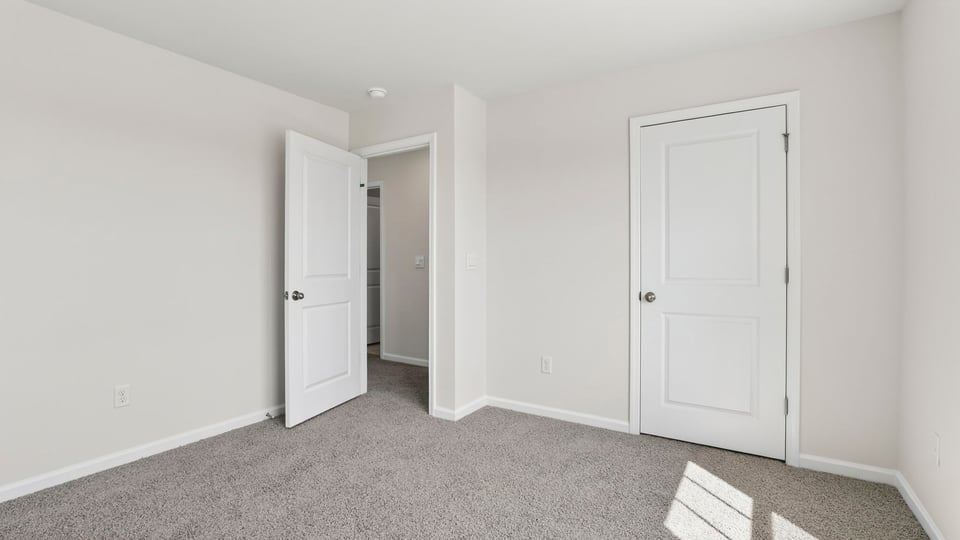 Bedroom with carpet and windows.