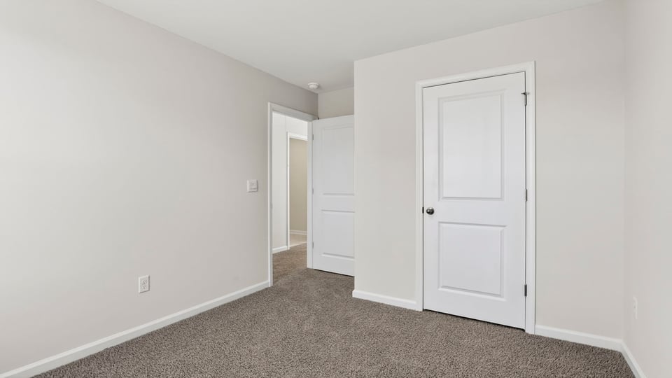 Bedroom with carpet and windows.