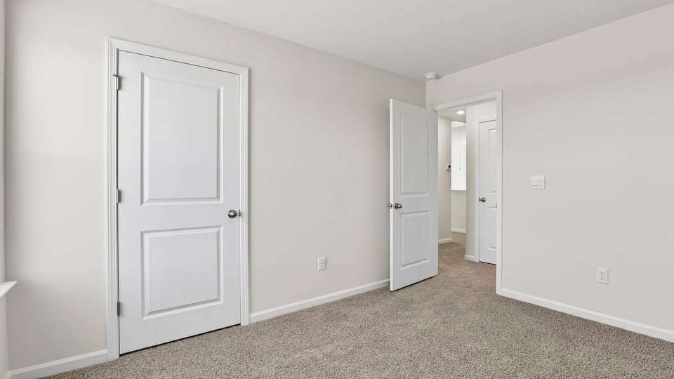 Bedroom with carpet and windows.