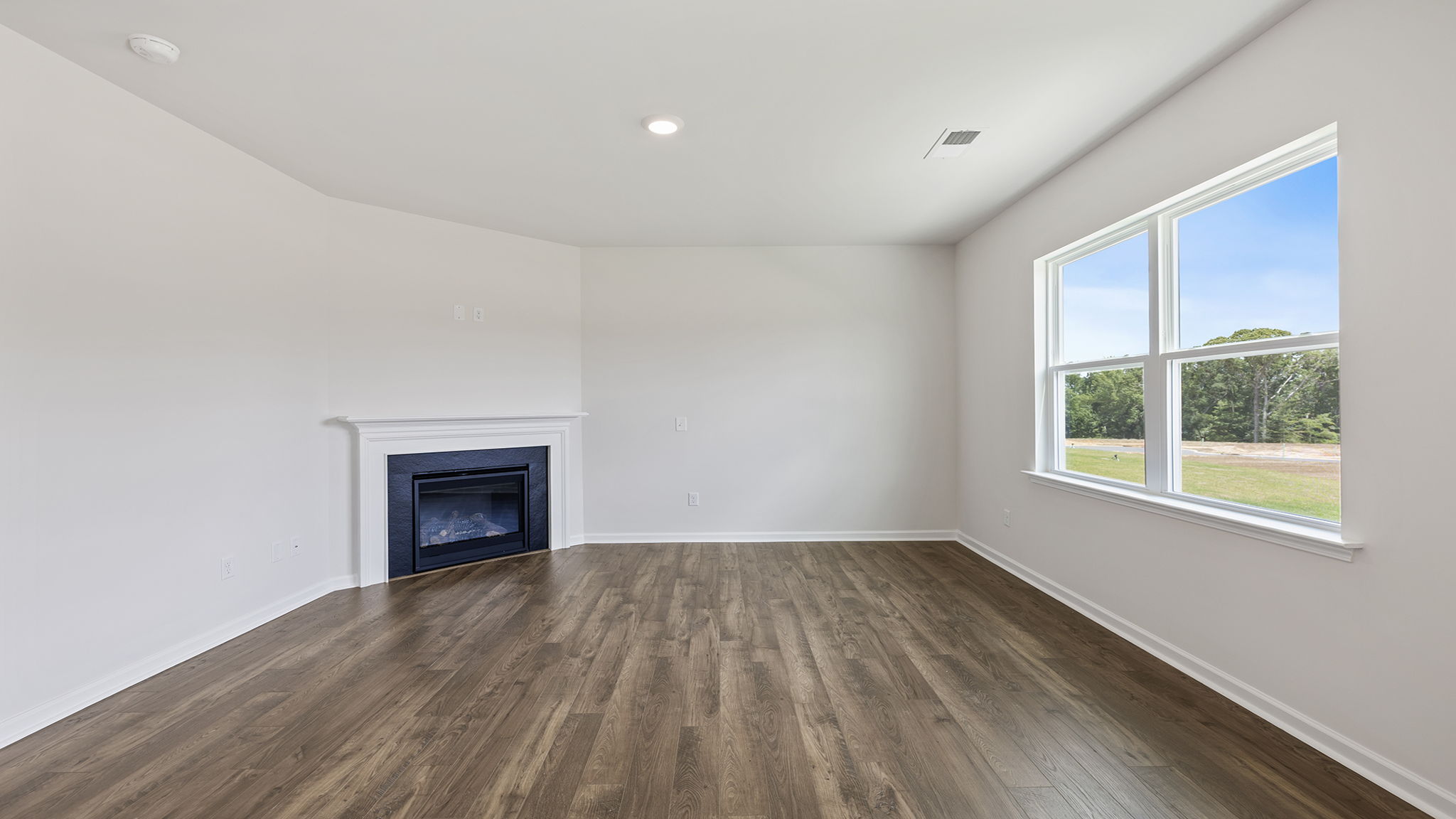 Family room with large windows and gas log fireplace.