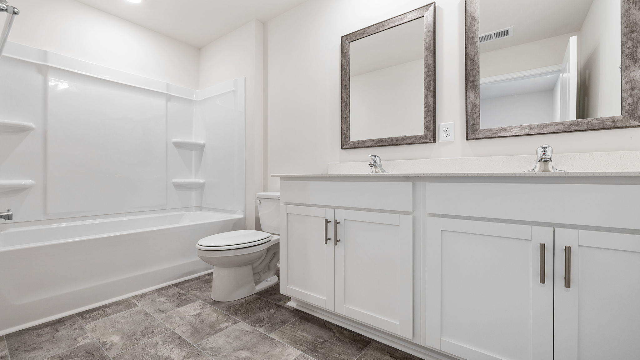 Hall bathroom with dual sink vanities and combination shower / tub.