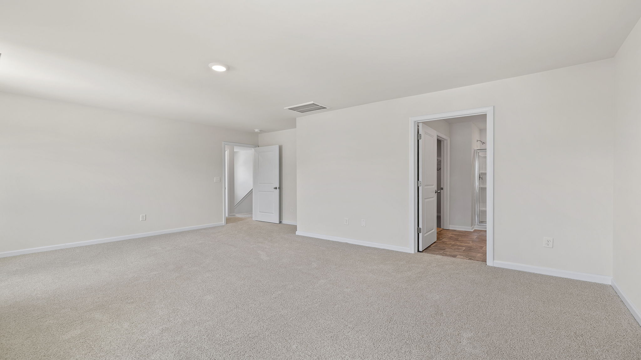 Primary bedroom with recessed lighting and two large windows.