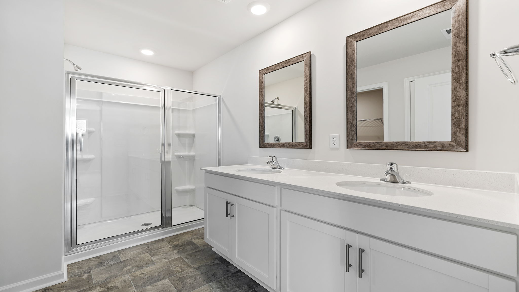 Primary bathroom with dual sink vanity and walk-in shower.
