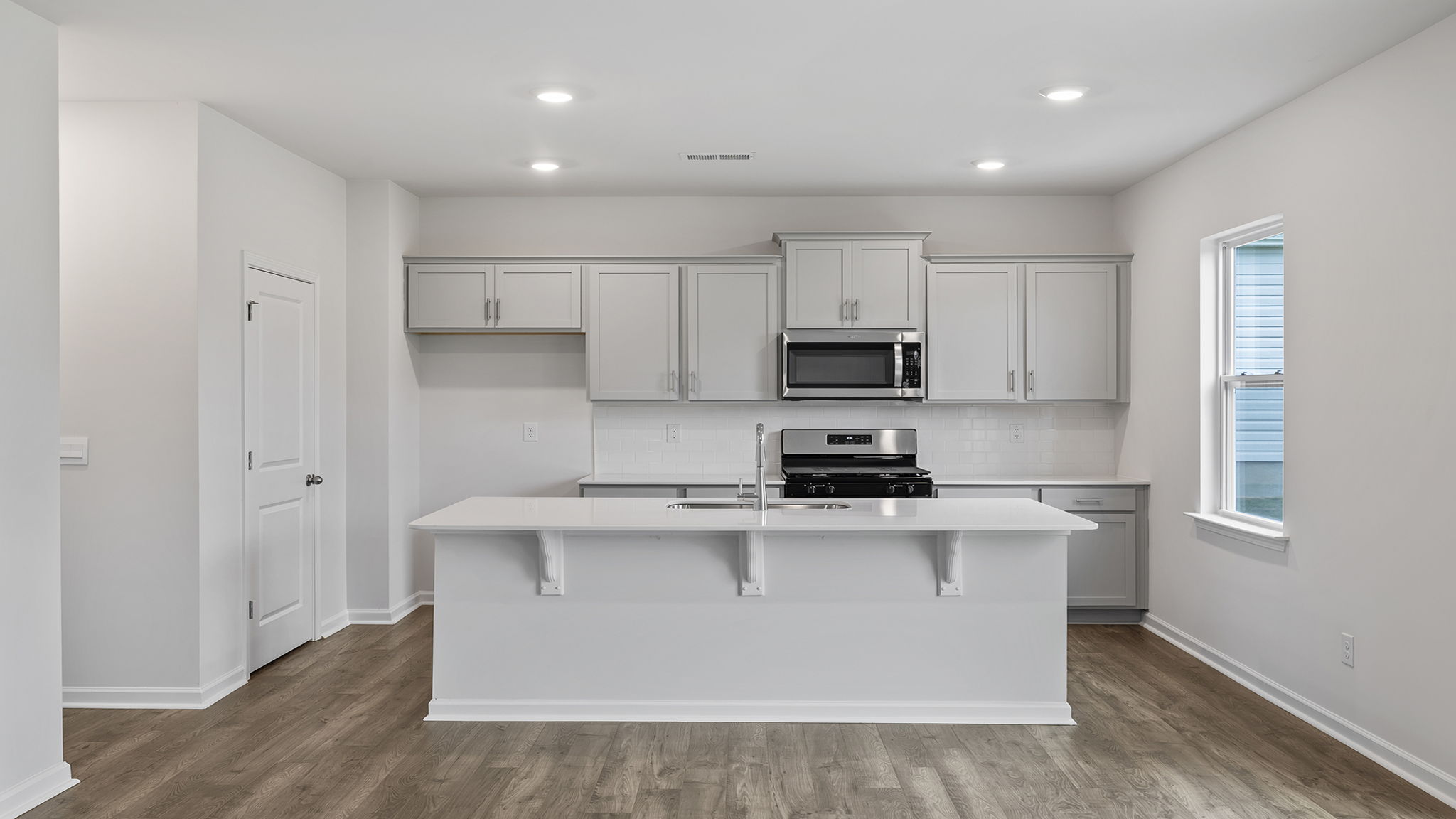 Kitchen area with quartz countertops and stainless-steel appliances.