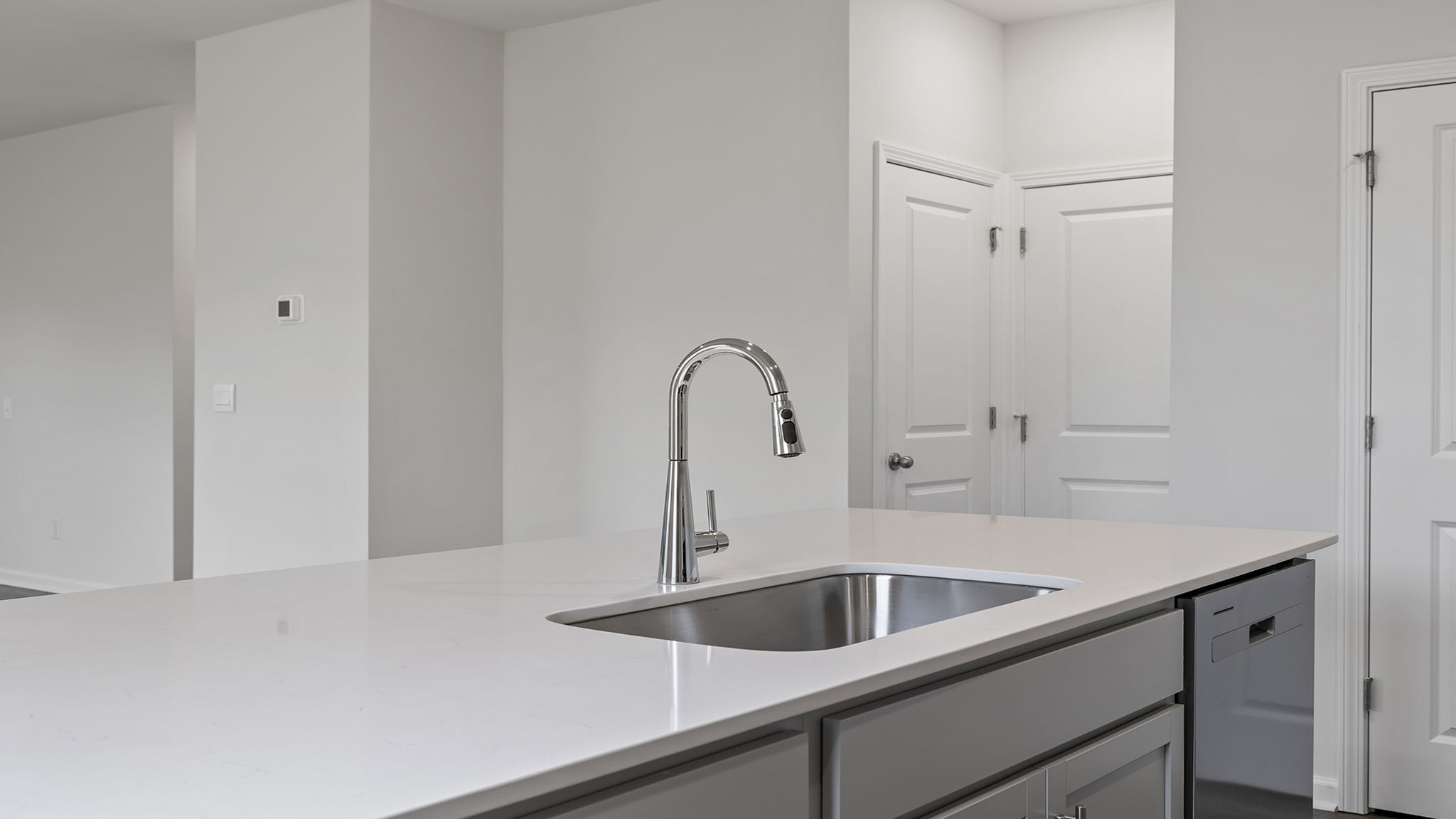 Kitchen island hosts the sink and dishwasher.