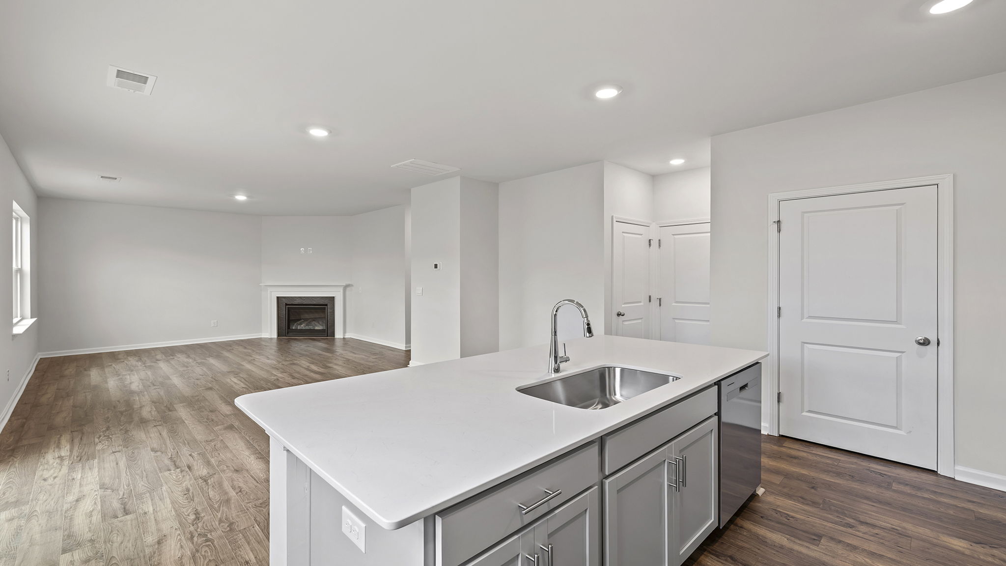 View of great room with gas log fireplace and large windows.
