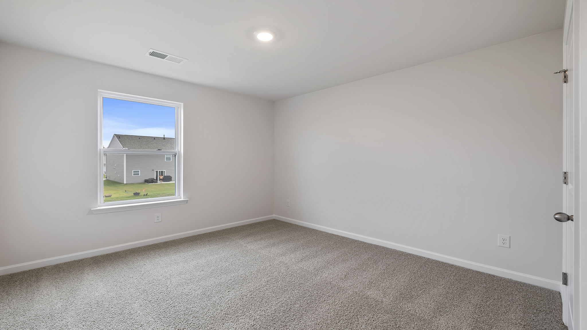 Bedroom with large window and carpet.