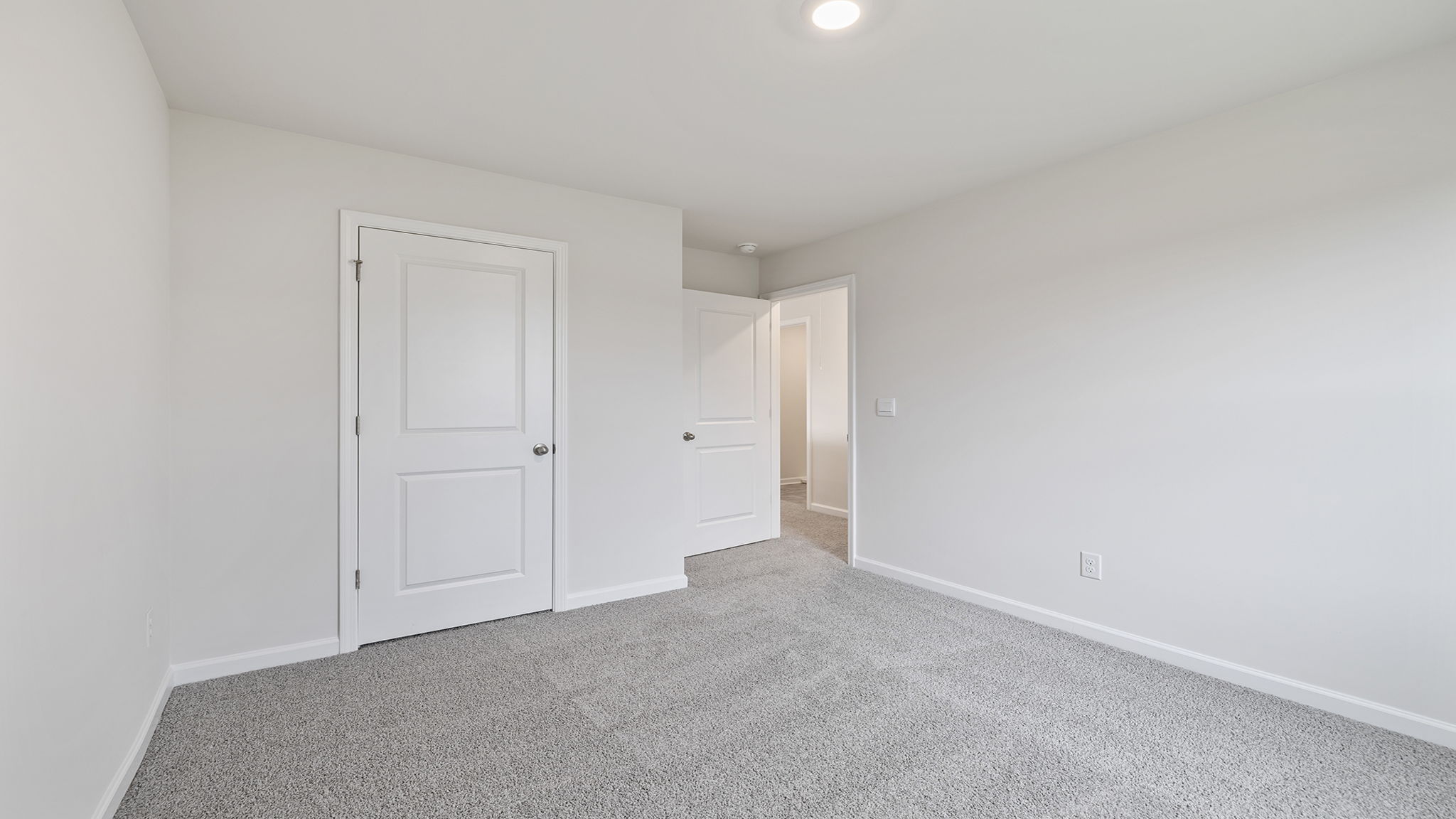Bedroom with large window and carpet.