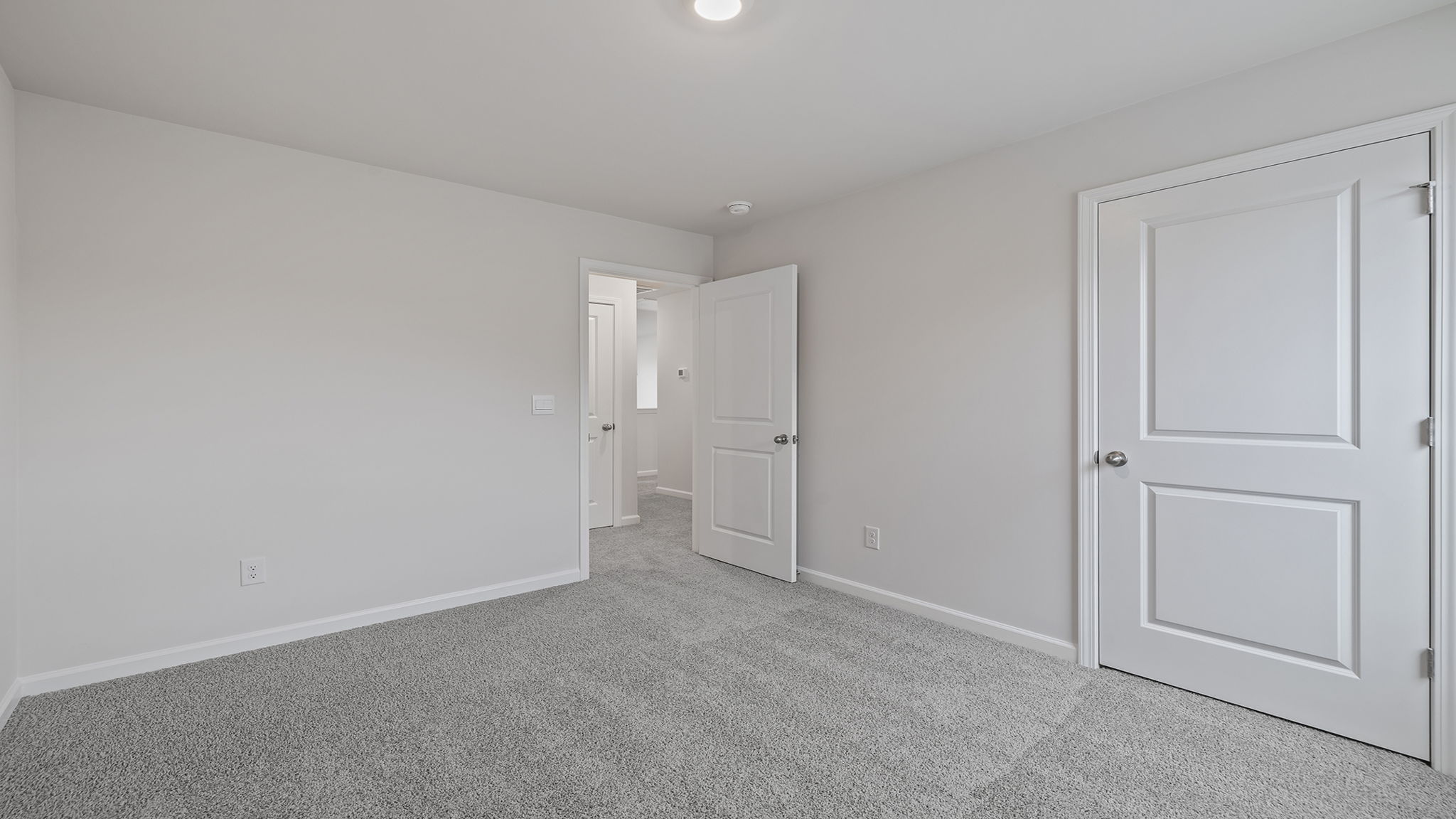 Bedroom with large window and carpet.