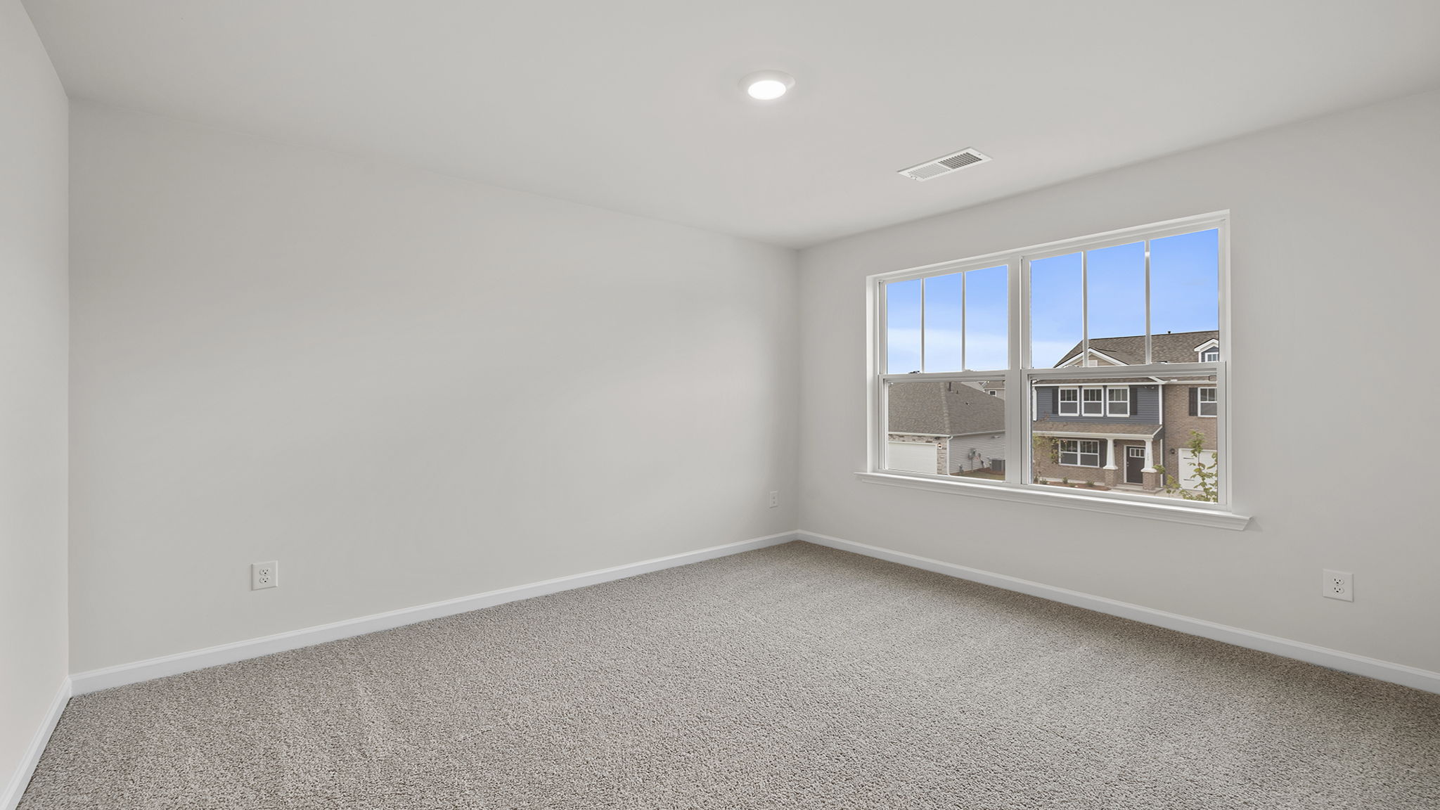 Bedroom with large window and carpet.