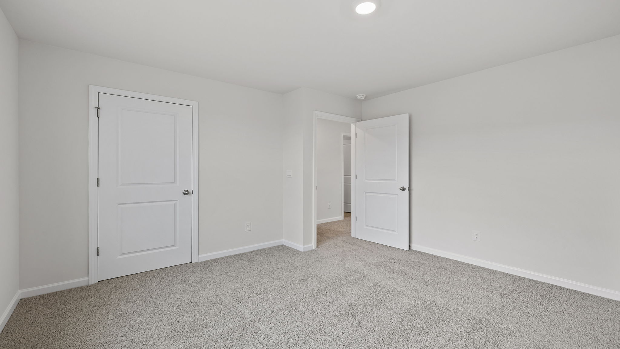 Bedroom with large window and carpet.