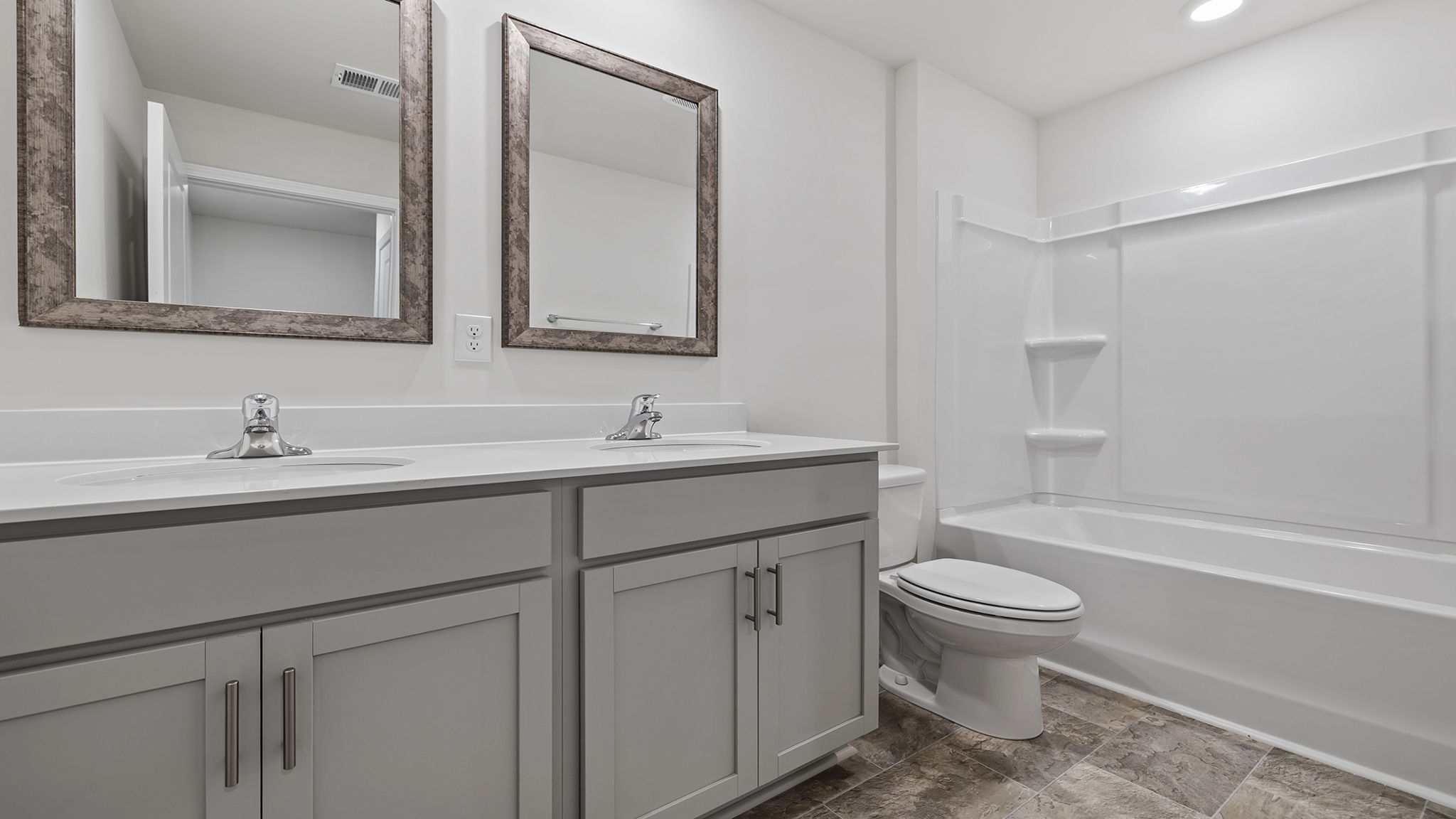 View of hall bath with dual sinks and combination tub and shower.