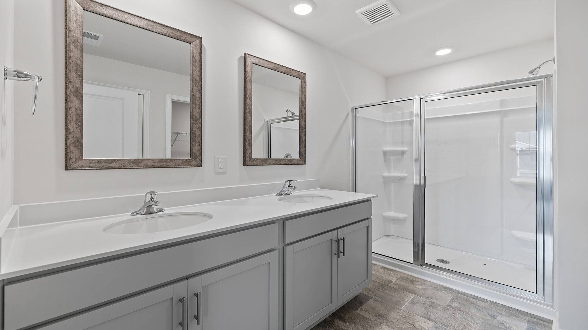 Primary bath with walk in shower and dual sink vanity.